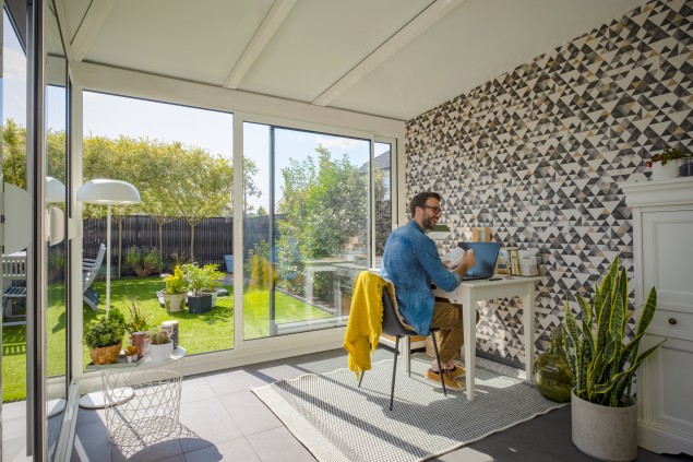 Un bureau qui stimule la concentration
Vous manquez d’un espace bureau pour travailler confortablement et paisiblement les jours de télétravail ? Aménagez votre véranda de petite superficie en un bureau agréable qui stimule votre productivité et votre créativité. La lumière naturelle venant directement des surfaces vitrées de la véranda vous évitera d’ailleurs une fatigue oculaire prématurée. Placez simplement votre table de travail près d’une fenêtre pour admirer l’environnement. Associez-la avec une chaise de bureau moelleuse et douillette. Vous pouvez aussi installer votre bureau au centre de la pièce pour profiter d’une vue à 180°. Ajoutez avec parcimonie des touches de bleu, de vert et de jaune pour dynamiser le style. 
